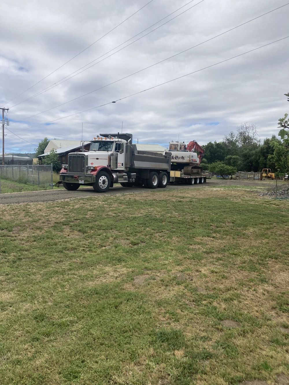 Russco's full-size excavator loaded on a trailer behind the 10-yard dump truck, ready to move to a job site in Douglas County.